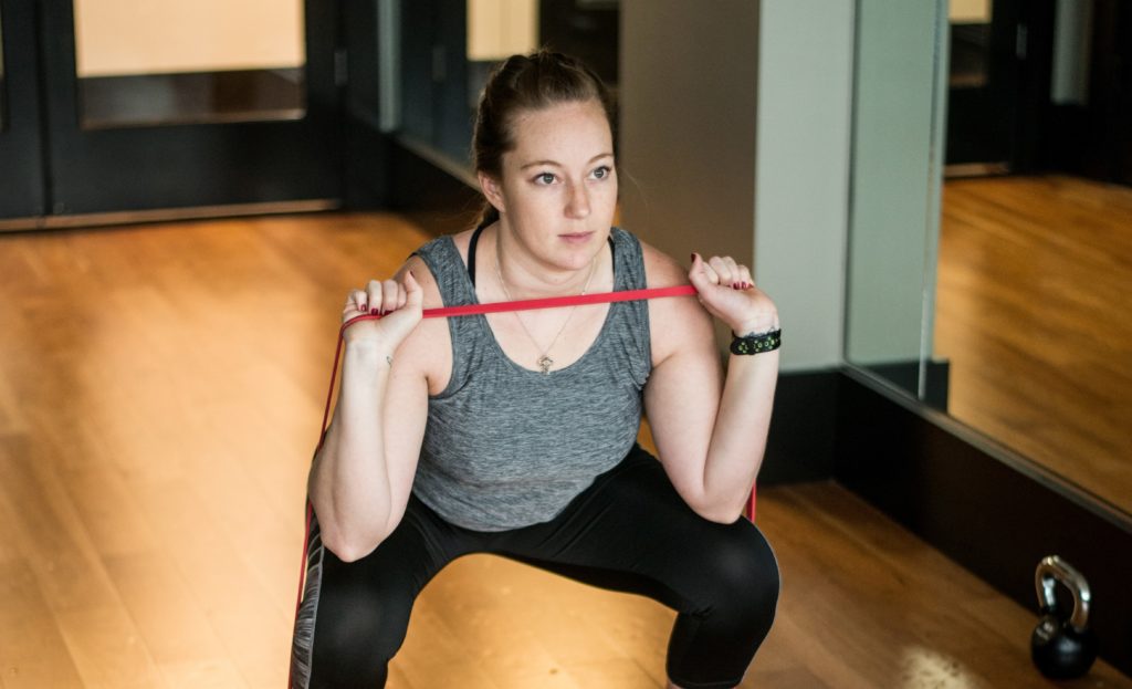 Woman squatting with resistance band