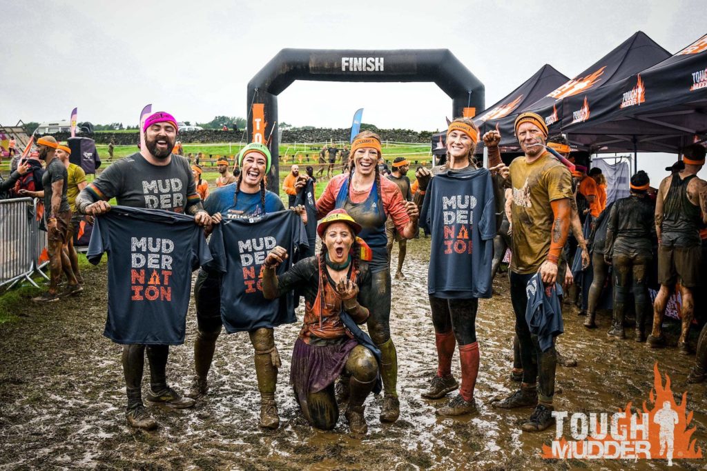 A team taking a picture in the finish line with their muddernation shirts